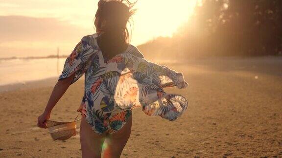 金色的阳光下一个女孩在沙滩上行走