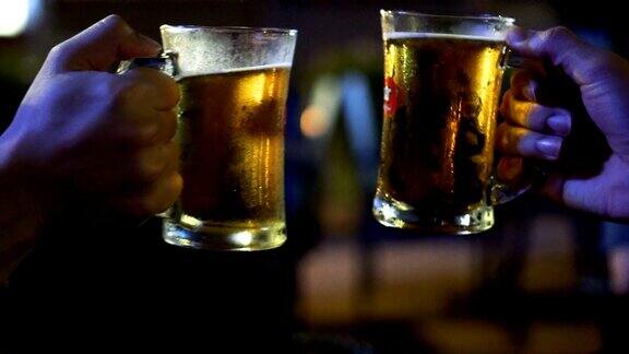 慢动作FHD镜头的两个亚洲人祝酒和碰杯啤酒一起在酒吧和餐厅欢呼放松和饮料