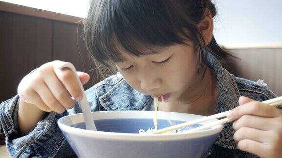 亚洲女孩用筷子吃美味的面条