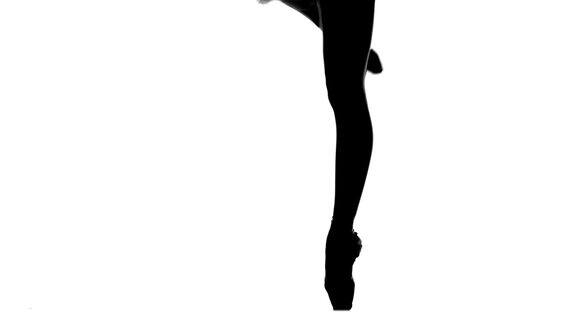 年轻的芭蕾舞演员跳舞特写腿和鞋站在尖的位置轮廓