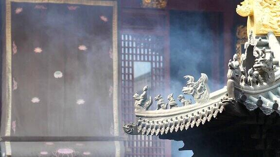 在中国传统寺庙的建筑屋檐上有神仙和野兽随着风中升起的烟超慢的动作