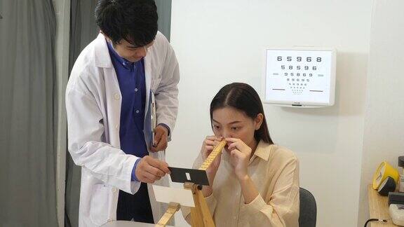 男性验光师用孔径卡为女性病患做眼保健操