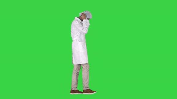 阿拉伯医生在绿色屏幕上行走戴着医用帽