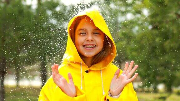 在雨天穿着雨衣在户外微笑的少女