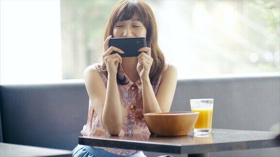 可爱的亚洲女孩用智能手机拍照