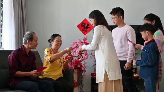 亚洲家庭在春节期间拜年问候和接受来自父母和祖父母的春节红包