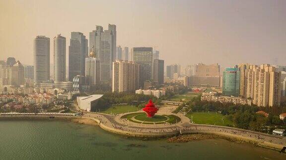 阳光明媚的一天飞越青岛著名的海湾纪念碑广场空中延时全景4k中国