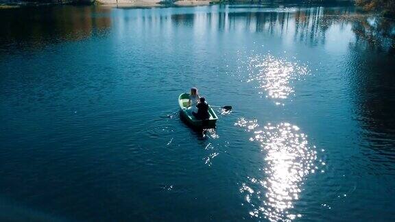 年轻的新婚夫妇在美丽的湖面上划船鸟瞰图