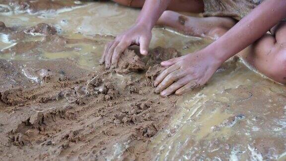 贫困的孩子们在泥泞的水里快乐地玩耍
