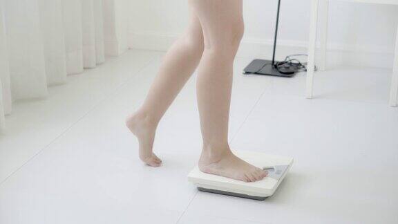 生活方式活动与腿的妇女行走测量体重秤的饮食特写脚的女孩苗条称重测量食物控制健康保健和幸福