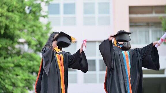 大学毕业生在毕业典礼上举起帽子祝贺他们