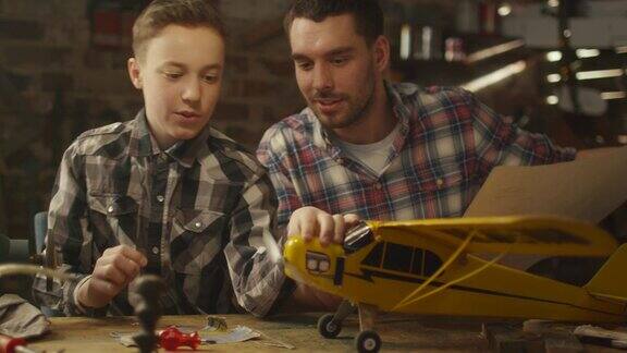 父亲和儿子正在家里的车库里制作玩具飞机