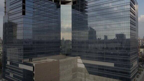 玻璃幕墙的摩天大楼靠近旧的多套公寓大楼镜头从新楼移到旧房子鸟瞰图