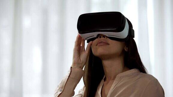 惊讶的女性在虚拟现实中玩视频游戏在虚拟现实中旋转头部