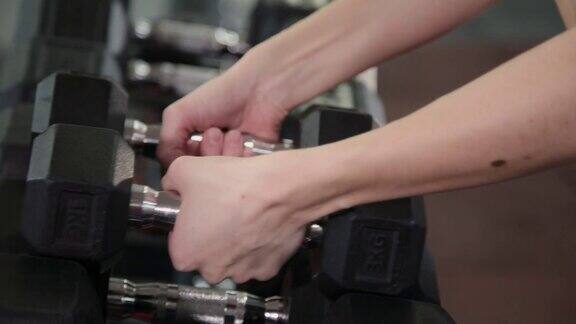 体操女子力量训练举起哑铃为锻炼做准备女健身女孩在健身中心室内锻炼