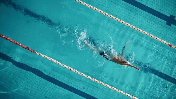 鸟瞰图:游泳池中肌肉发达的男性游泳者职业运动员仰泳训练中必胜电影旋转镜头与时尚的颜色