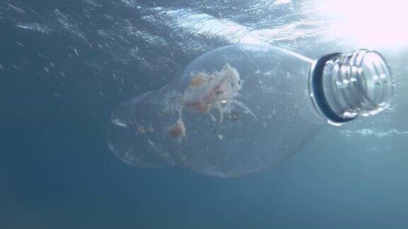 塑料污染水母被困在塑料瓶中死亡废弃的透明塑料瓶漂浮在蓝色的水面下里面装着死去的水母地中海、欧洲