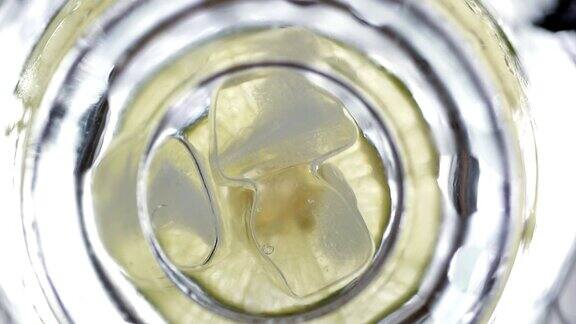 从底部看慢动作将柠檬片冰块放入玻璃杯中倒入苏打水