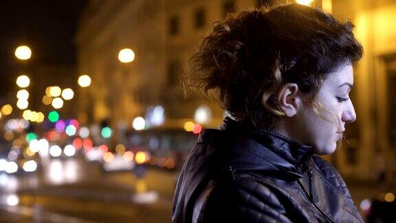 悲伤紧张的女人独自在夜晚的城市里等待着某人