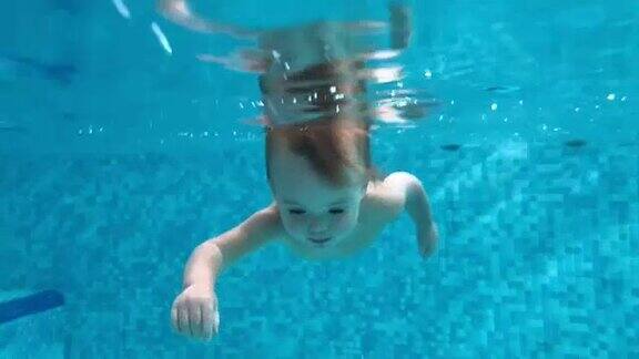 蹒跚学步的孩子在游泳池的水下潜水