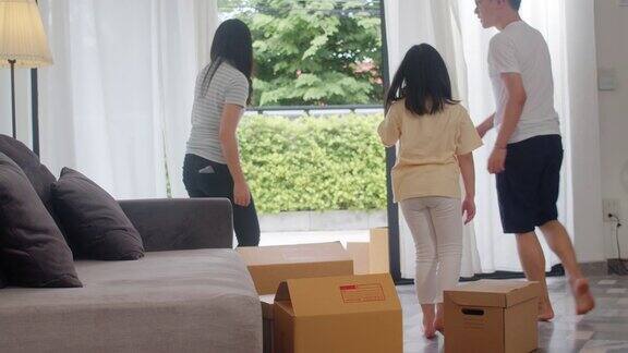 快乐的亚洲年轻家庭买了新房中国妈妈爸爸和孩子笑着开心地拿着纸板箱移动物体在大的现代家庭新房地产住宅贷款和抵押