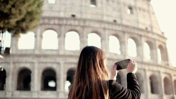 年轻的黑发游客探索罗马斗兽场意大利女人用智能手机拍照