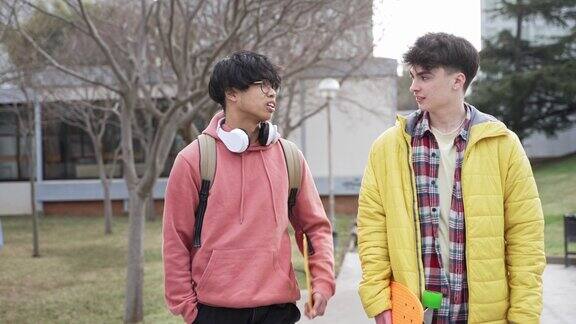 大学生朋友们背着背包和笔记本在大学校园里散步关注亚洲男性