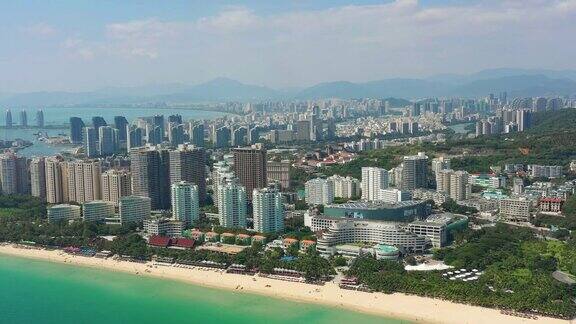 阳光明媚的三亚著名的大东海镇海滩湾高空俯瞰4k中国海南全景