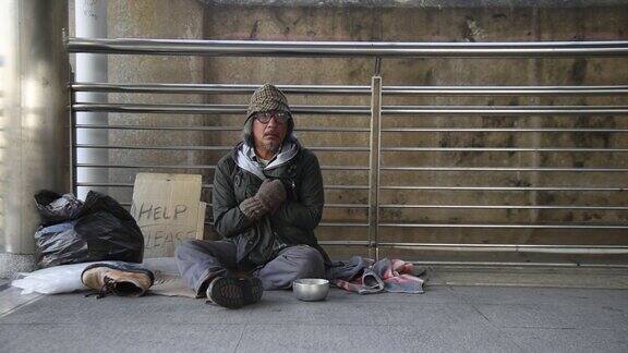 一个无家可归的人坐在地板上