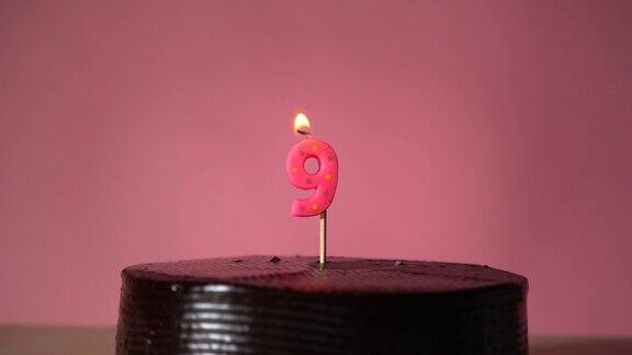 巧克力生日蛋糕与灯芯点燃试图吹灭蜡烛
