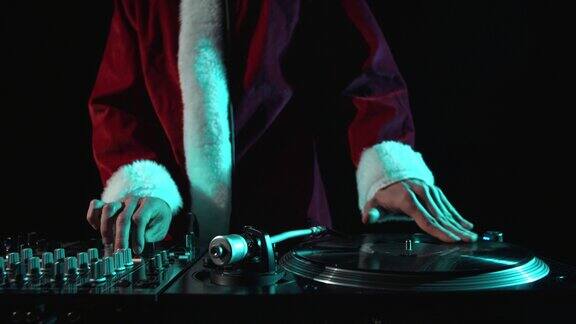 圣诞派对上的嘻哈dj穿着红色圣诞老人服装的音乐节目主持人在转盘上刮擦黑胶唱片