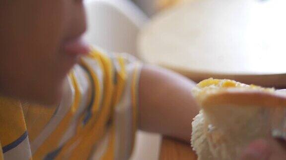 亚洲女孩在家窗前吃玉米蛋黄酱包(玉米面包)慢镜头