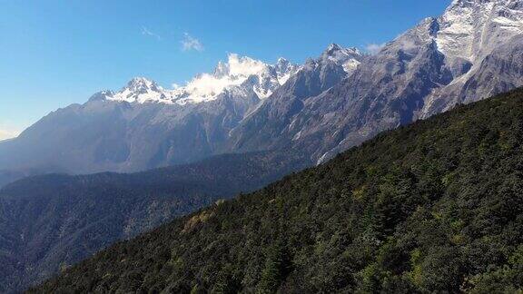 中国丽江的林地和玉龙雪山景观的4k鸟瞰图和移动摄影