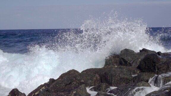 海浪拍打岩石海岸的石头与水花在慢动作
