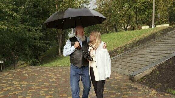 40、老男人在雨中与年轻女人在公园散步方便婚姻