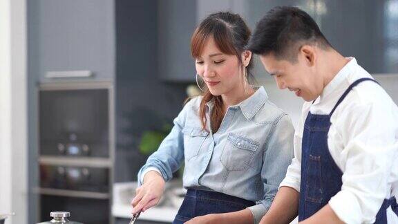年轻的亚洲夫妇在厨房做饭