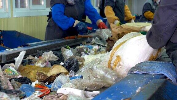 垃圾输送机在回收厂工人们在传送带上整理垃圾