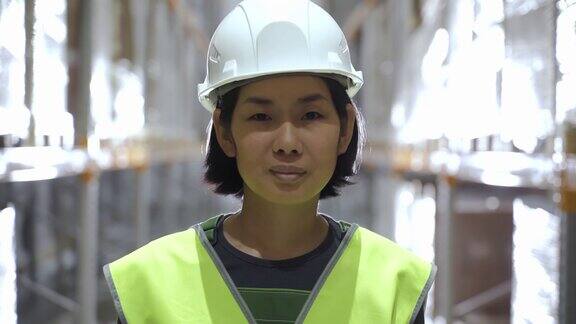 亚洲女人的肖像微笑站在仓库看着相机仓库工人