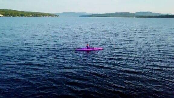 4K航拍视频健康妇女在湖上的日出皮划艇