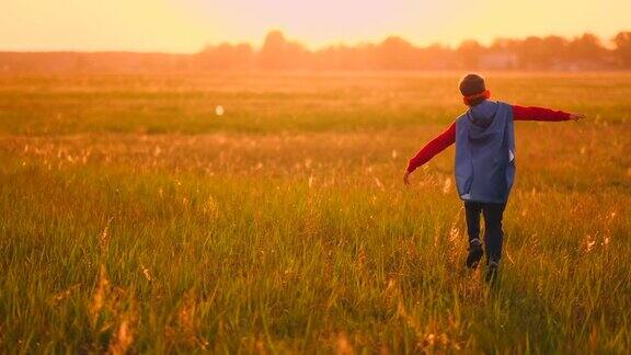 日落时分在田野里的小超级英雄幻想和梦想