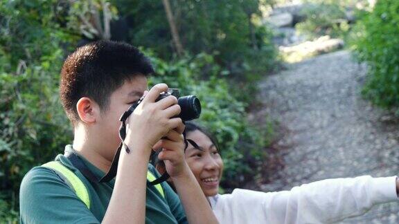 亚洲男孩和他的妹妹在森林里拍照户外冒险