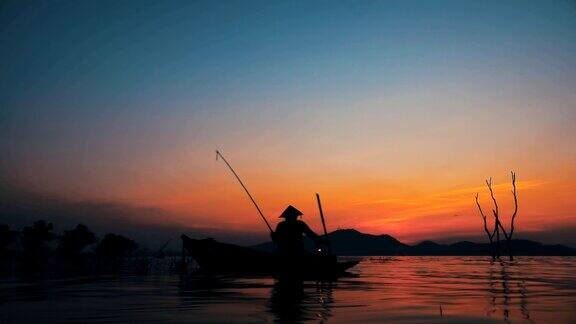 高清慢镜头:日落时分渔民在长尾船上捕鱼