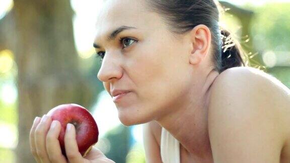 年轻女子在户外吃新鲜苹果