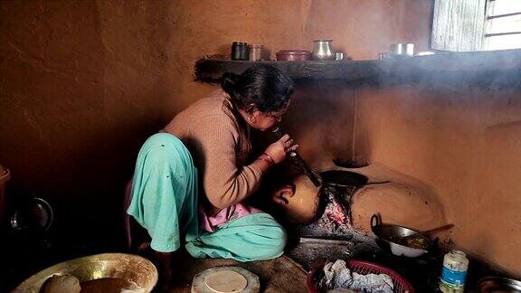 印度妇女在传统炉子上做饭(chulha)