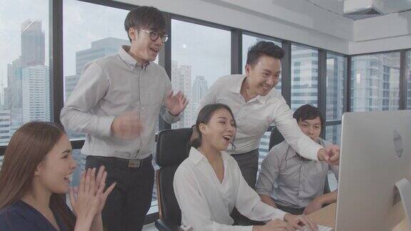 快乐亚洲商务团队在室内现代办公室欢笑和鼓掌庆祝亚洲商务生活