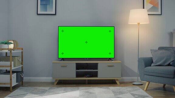 缩小镜头的电视水平绿色屏幕模拟起来舒适的客厅白天与椅子和灯打开在家里