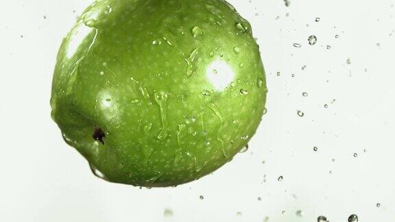 绿色苹果在白色厨房背景的飞行慢动作