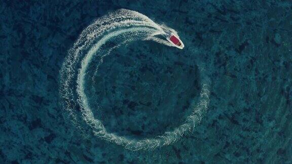 航拍一艘有红色屋顶的快艇绕着圈在海洋中做漂亮的甜甜圈