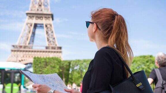 游客看巴黎城市地图然后抬头看埃菲尔铁塔