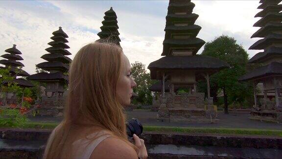 一名年轻女子和她的小儿子参观巴厘岛上的塔曼阿云皇家宫殿的慢镜头